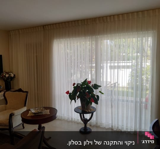 וילון לבן שקוף על חלון גדול בסלון מואר